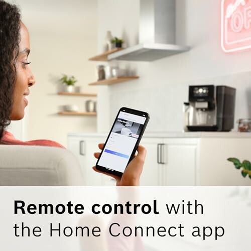 Person using phone to control home appliance with Home Connect app.